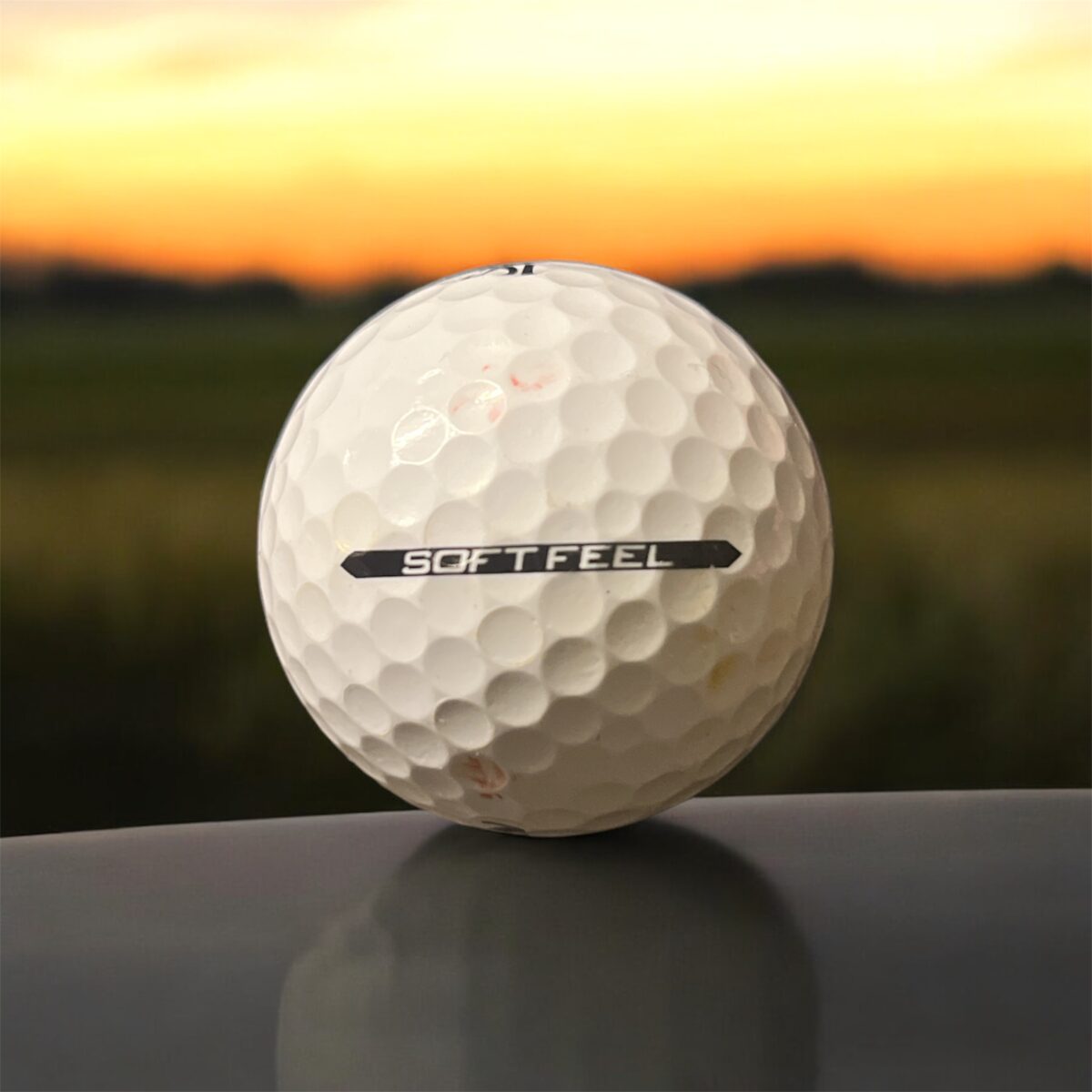 Återvunnen golfboll i vit färg av modellen Srixon SoftFeel fotad bakifrån