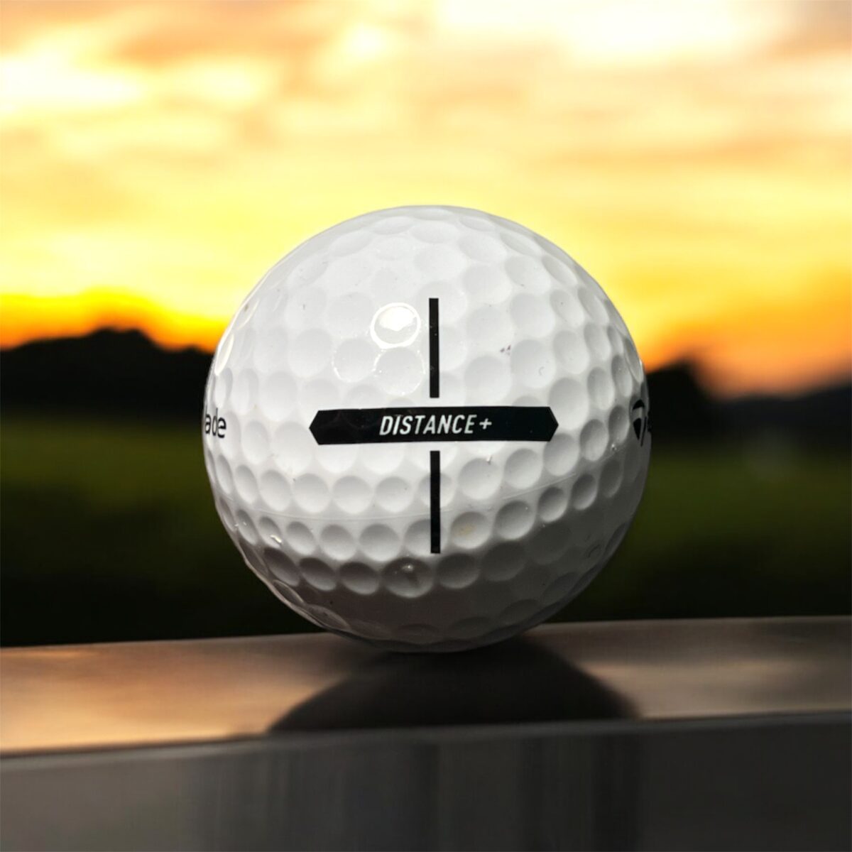 Återvunnen golfboll i vit färg av modellen Taylormade Distance+ fotad bakifrån