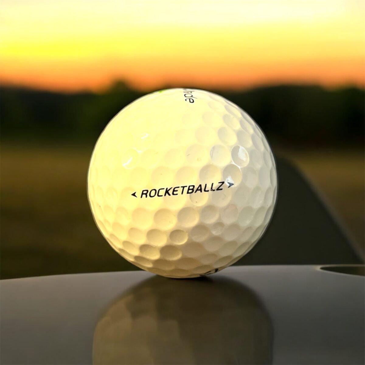 Återvunnen golfboll i vit färg av modellen Taylormade Rocketballz fotad bakifrån