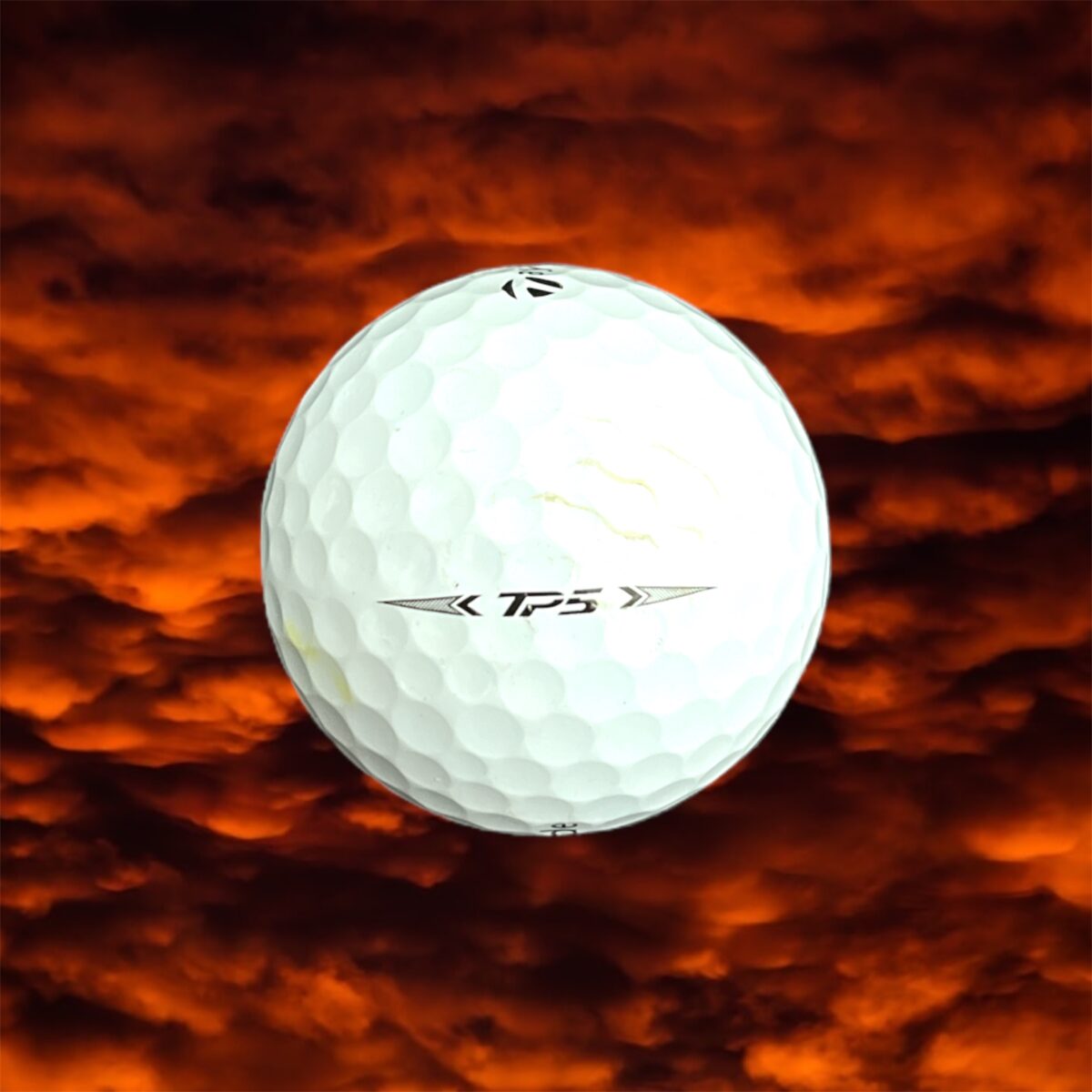 Återvunnen golfboll i vit färg av modellen Taylormade tp5 fotad bakifrån