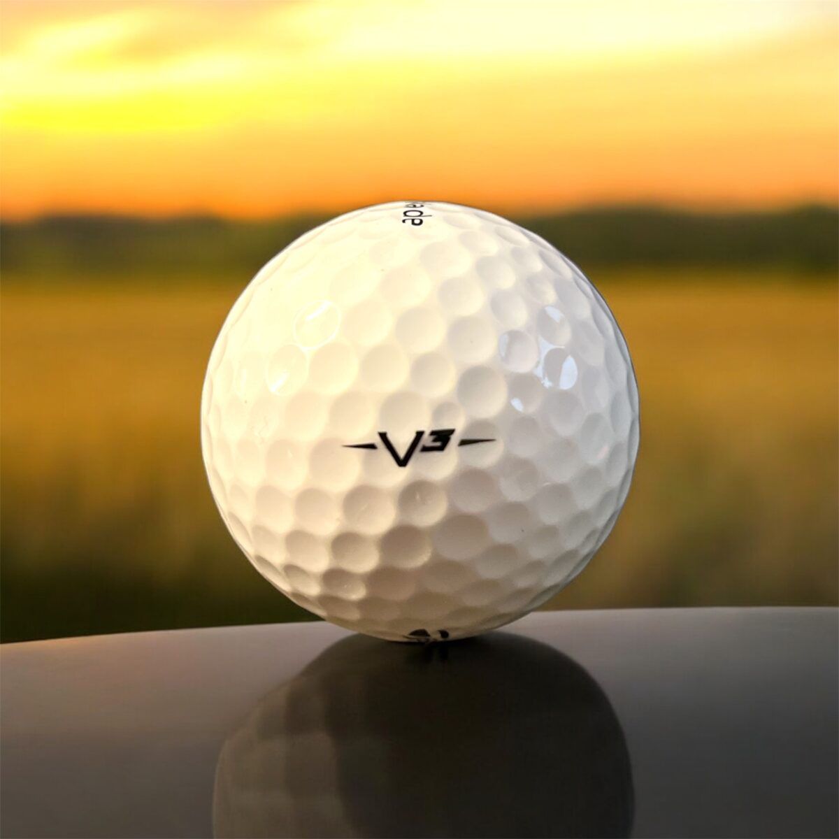 Återvunnen golfboll i vit färg av modellen Taylormade V3 fotad bakifrån