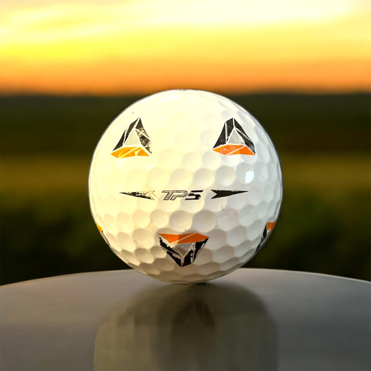 Återvunnen golfboll i vit färg av modellen Taylormade TP5 Pix fotad bakifrån