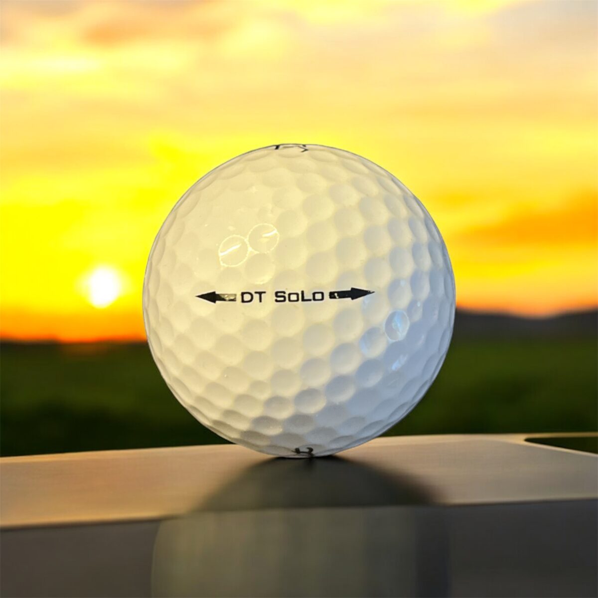 Återvunnen golfboll i vit färg av modellen titleist dt solo fotad bakifrån