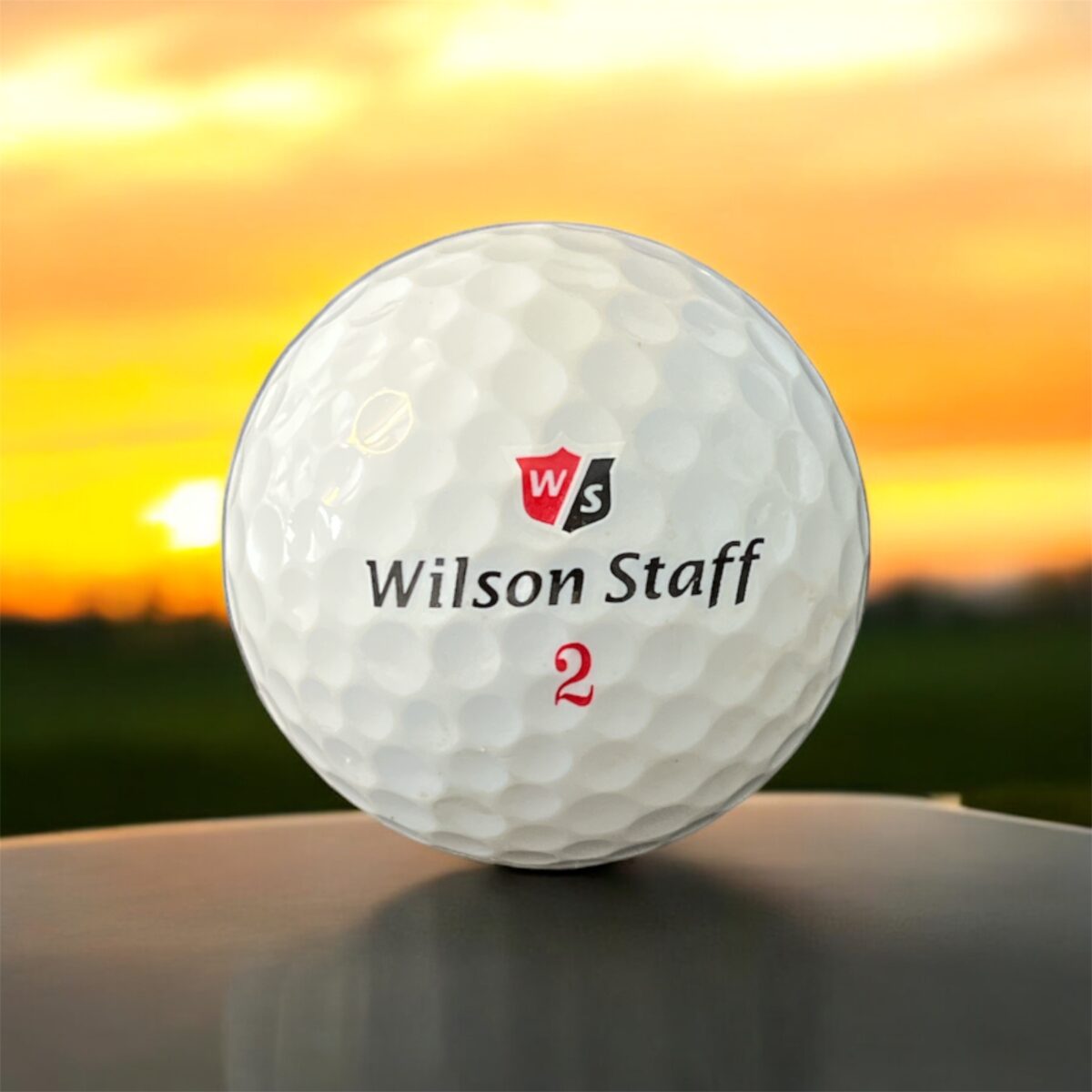 Återvunnen golfboll i vit färg av modellen Wilson DX2 soft fotad framifrån