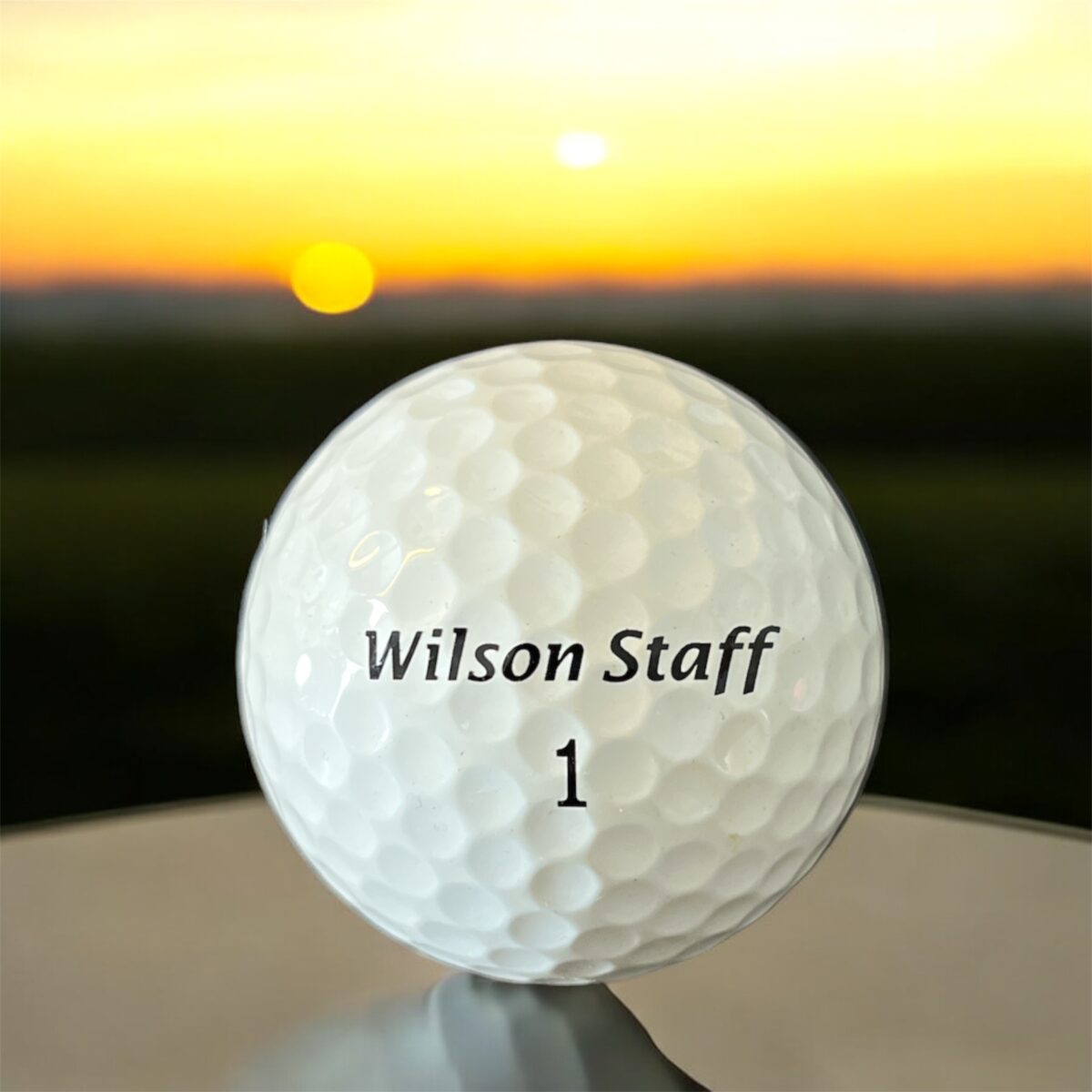 Återvunnen golfboll i vit färg av modellen Wilson FG Tour fotad framifrån