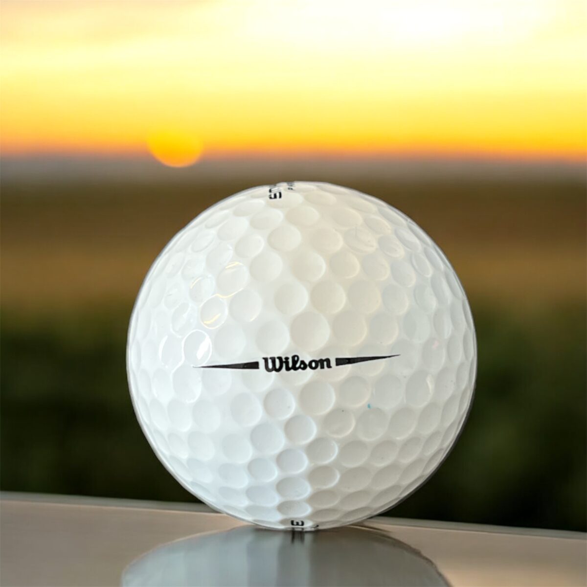 Återvunnen golfboll i vit färg av modellen Wilson Smartcore fotad bakifrån