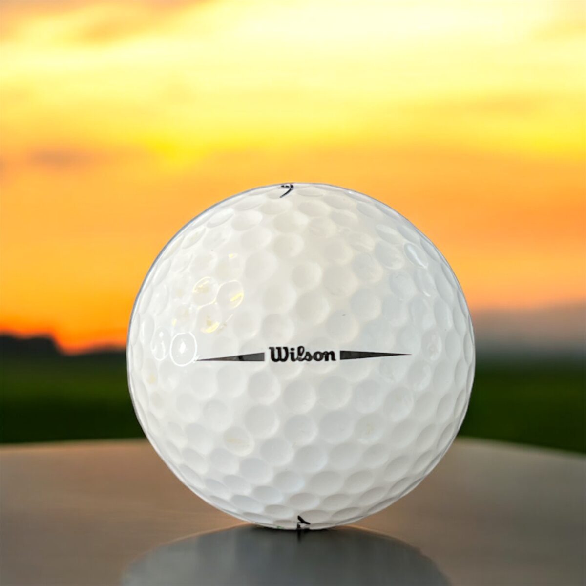 Återvunnen golfboll i vit färg av modellen Wilson tour velocity fotad bakifrån