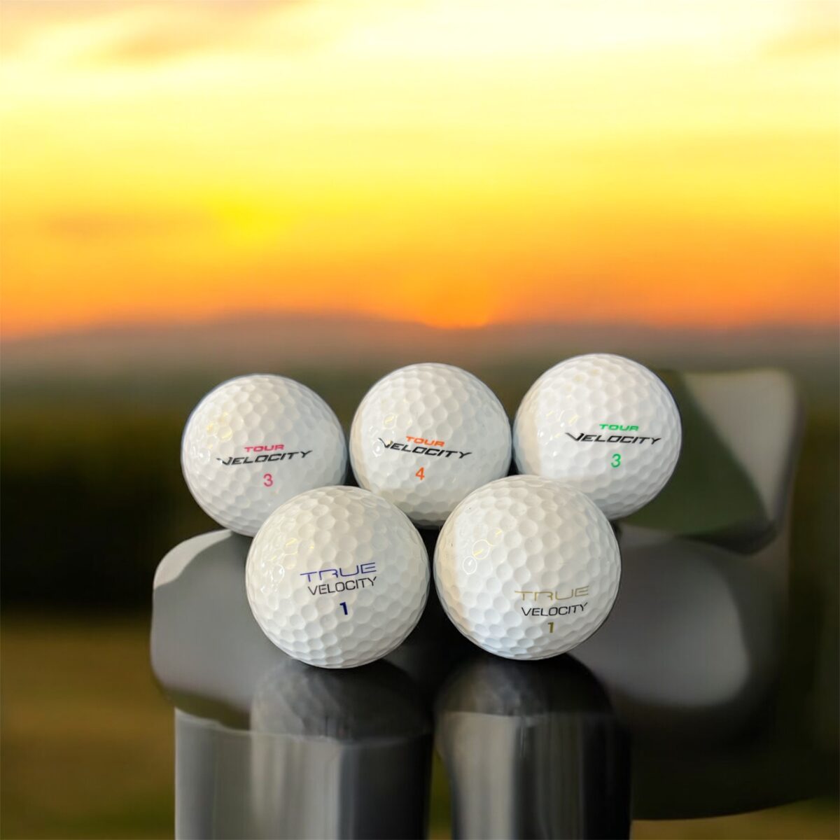 Återvunna golfbollar i vit färg av modellerna Wilson tour velocity och Wilson true velocity staplade bredvid varandra fotade framifrån